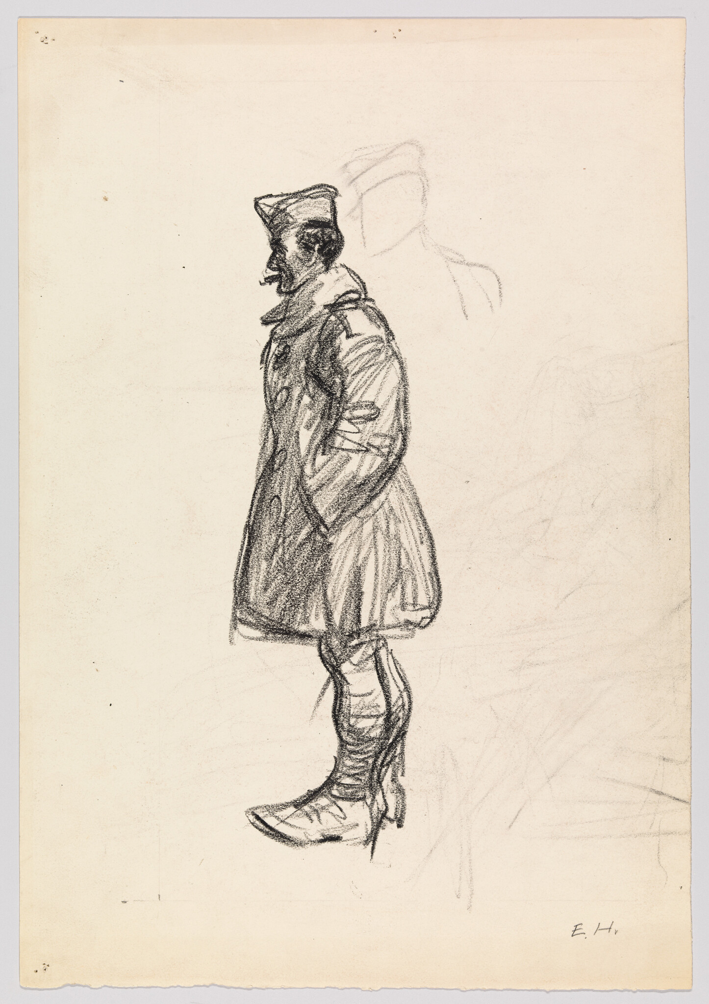 A standing soldier in a heavy coat and cap with hands in pockets.