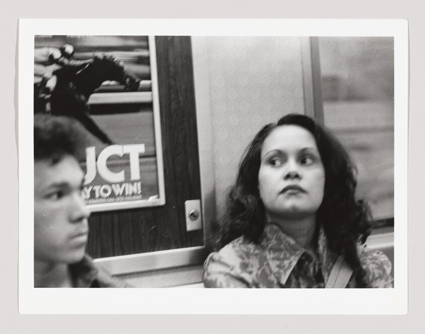 Young woman sitting on a subway looking aside with a pensive expression.