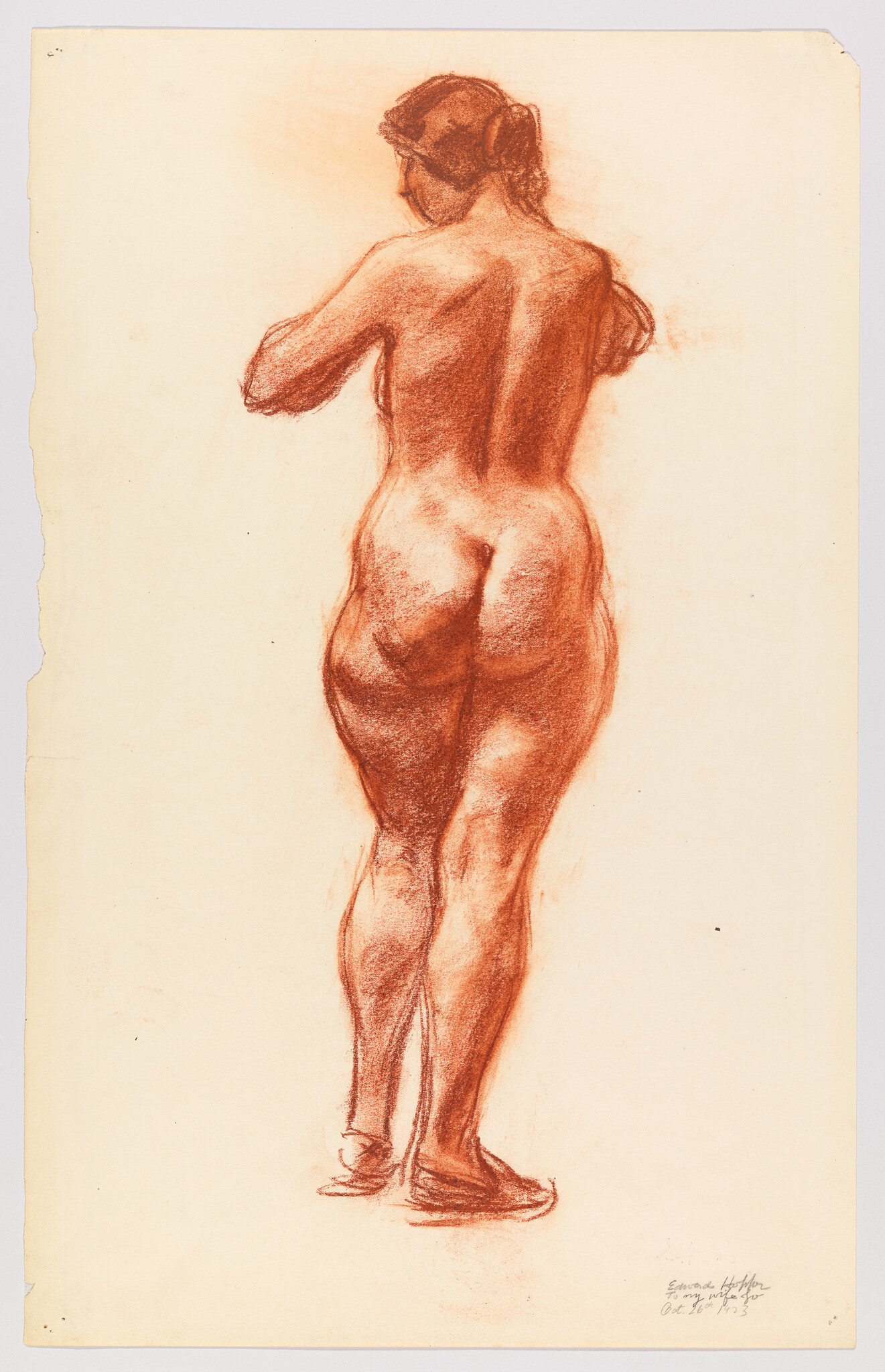 Standing nude woman seen from behind adjusting her arms, sketched in red chalk.