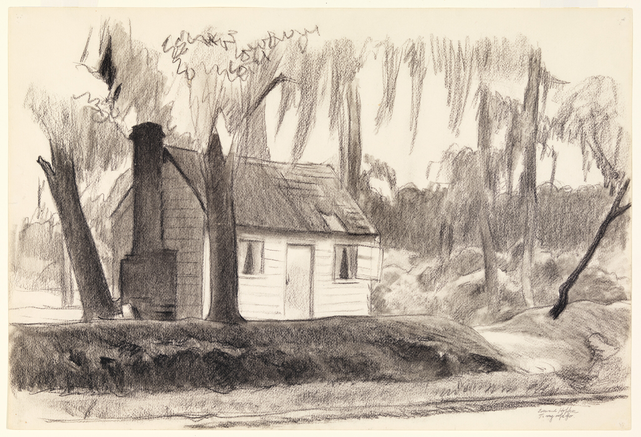 Small wooden cabin sits among tall trees beside a calm riverbank.