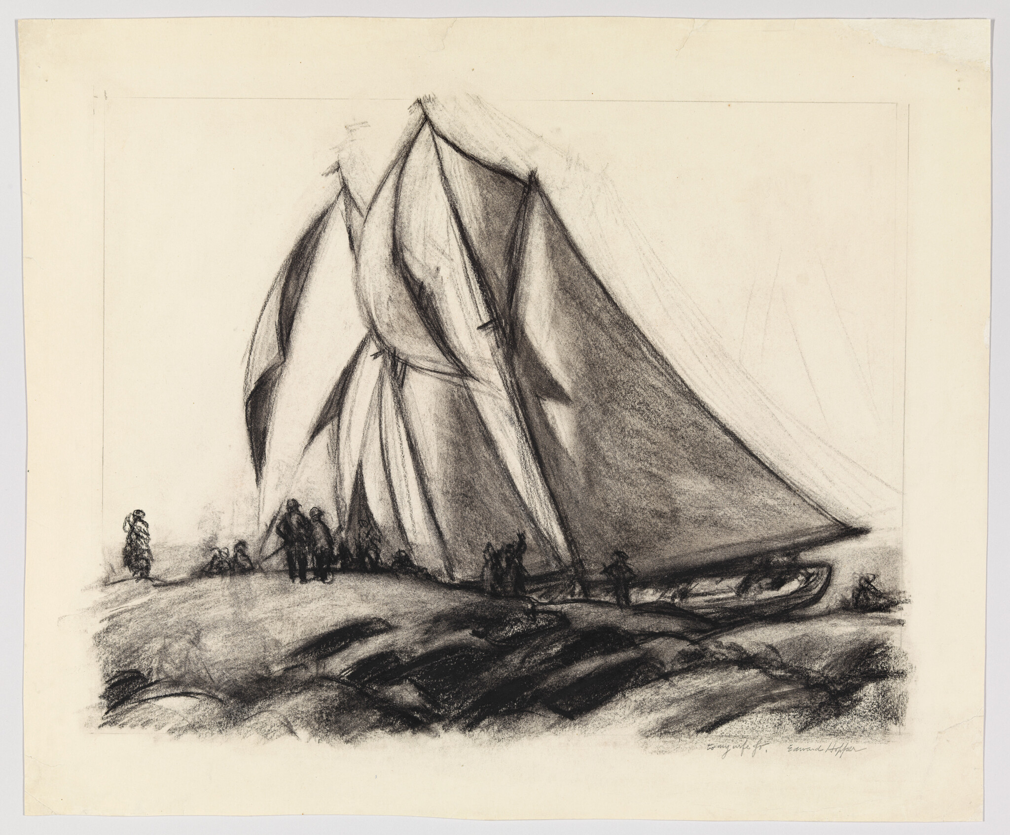 A large sailboat with towering sails rests on the shore while people stand nearby.