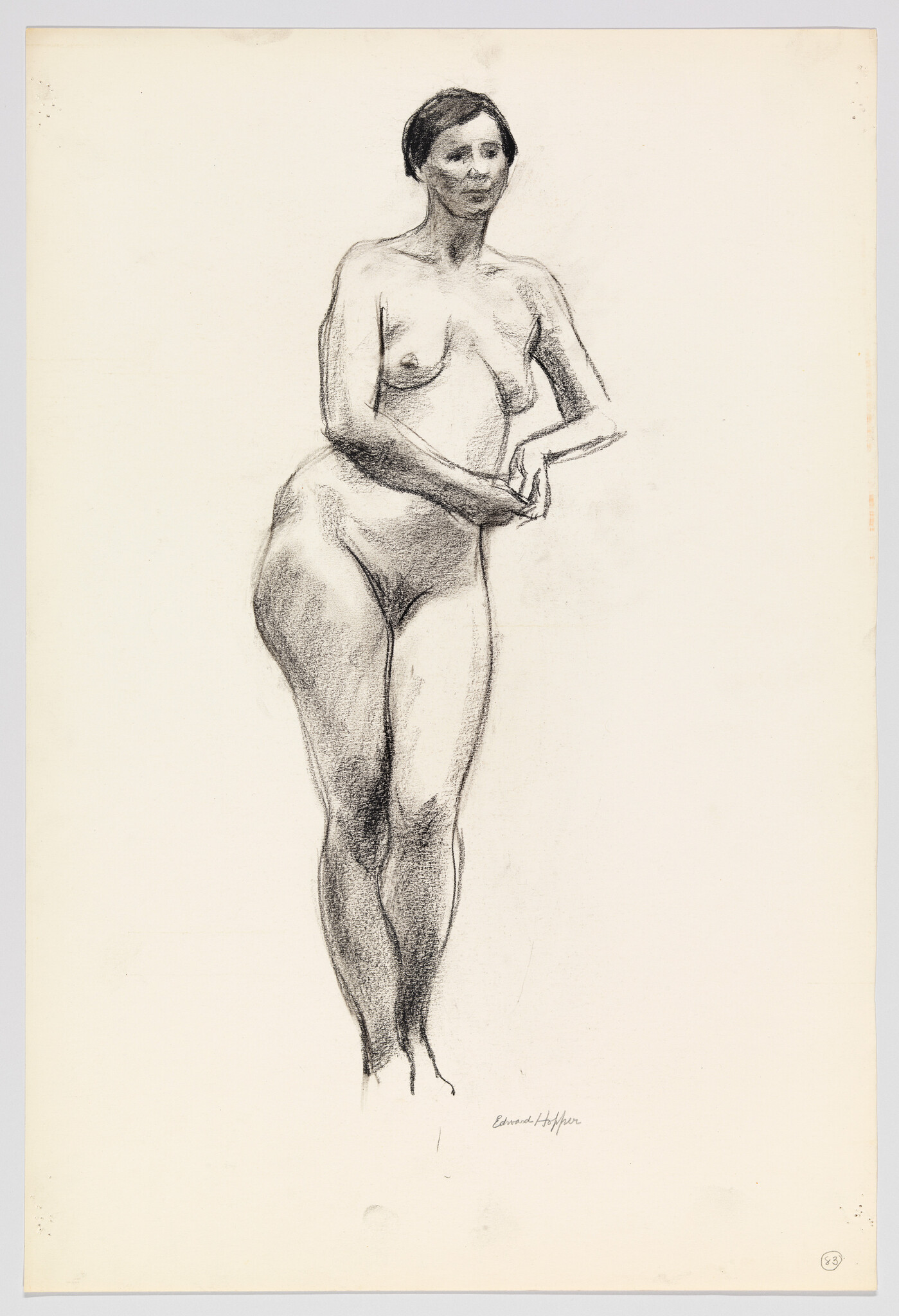 A charcoal drawing of a standing nude woman with hands clasped at her waist.