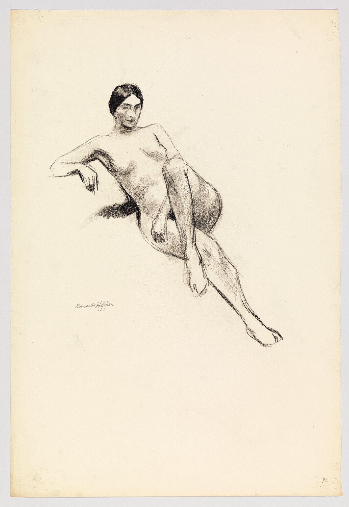 A charcoal sketch of a reclining nude woman with one arm draped and legs crossed.