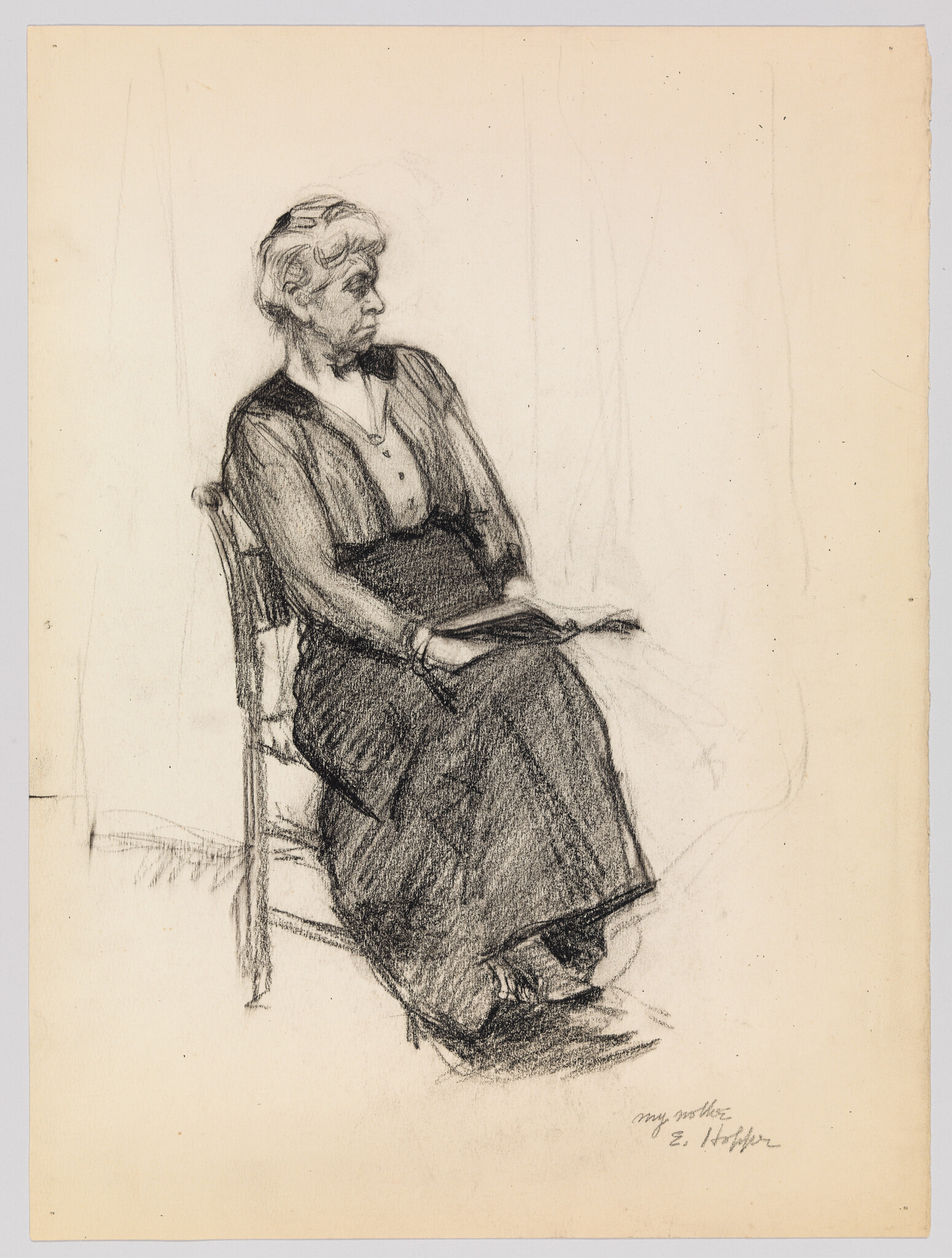 An older woman sits in a chair with folded hands, looking to her left.