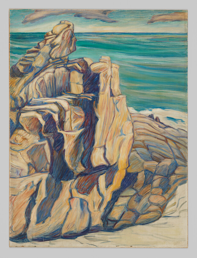 Large sunlit rocky cliff overlooking turquoise ocean with waves at the base.