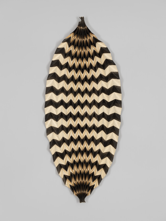 Large, leaf-shaped object with black and white zigzag pattern, folded in a textured, three-dimensional design.