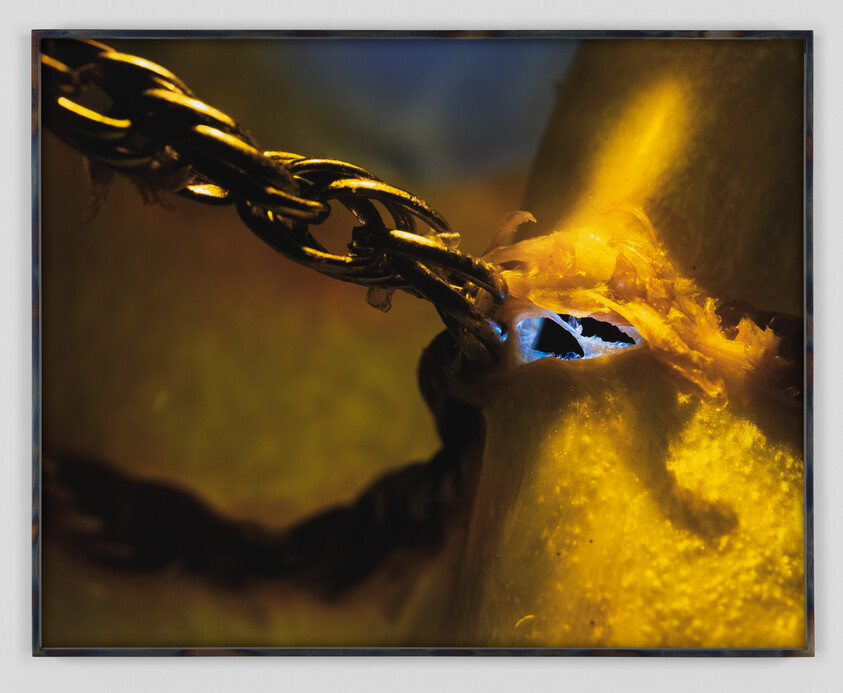 A metal chain links pull through a torn, glowing yellow surface revealing a blue hole.