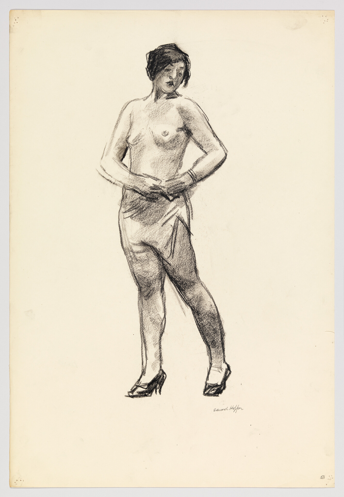 A standing woman wearing heels adjusts a skirt while posing partially undressed.