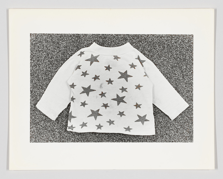 A child's grey long-sleeve shirt with star patterns on a speckled background, displayed flat.