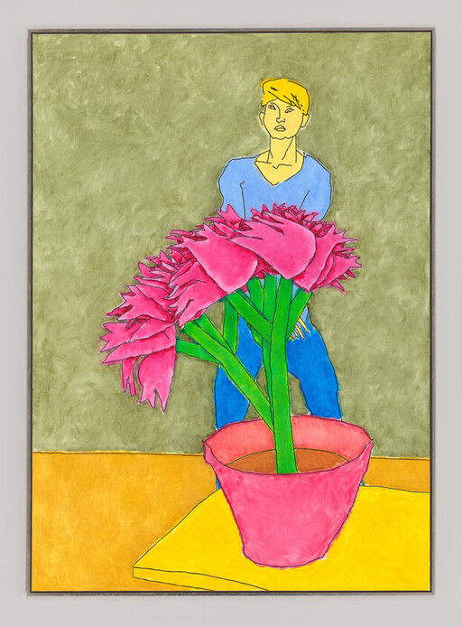 A person stands behind a table holding a large potted plant with bright pink flowers.
