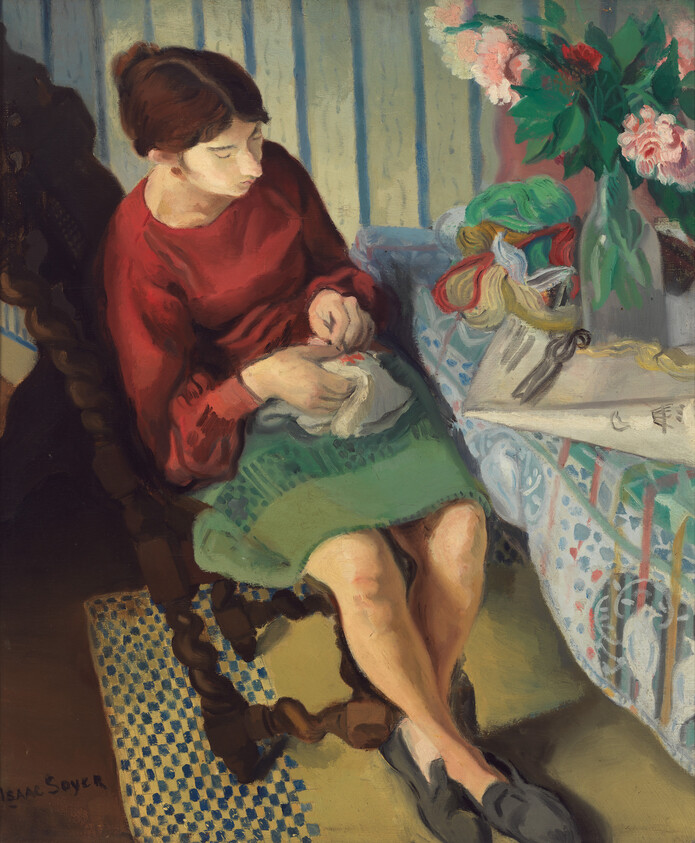 A woman in a red blouse sits sewing by a table with yarn and flowers.