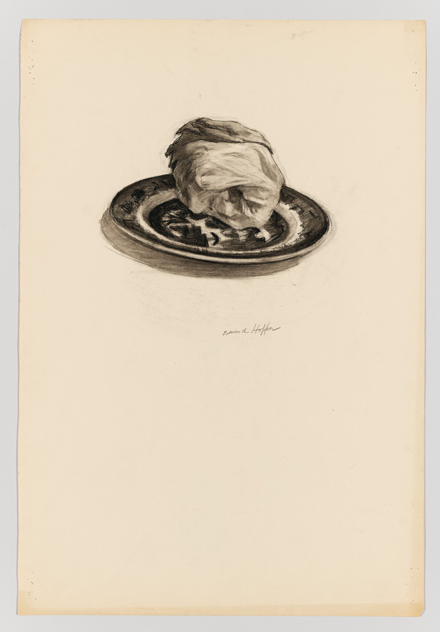 Charcoal drawing of a skull resting on a shallow plate centered on blank paper.