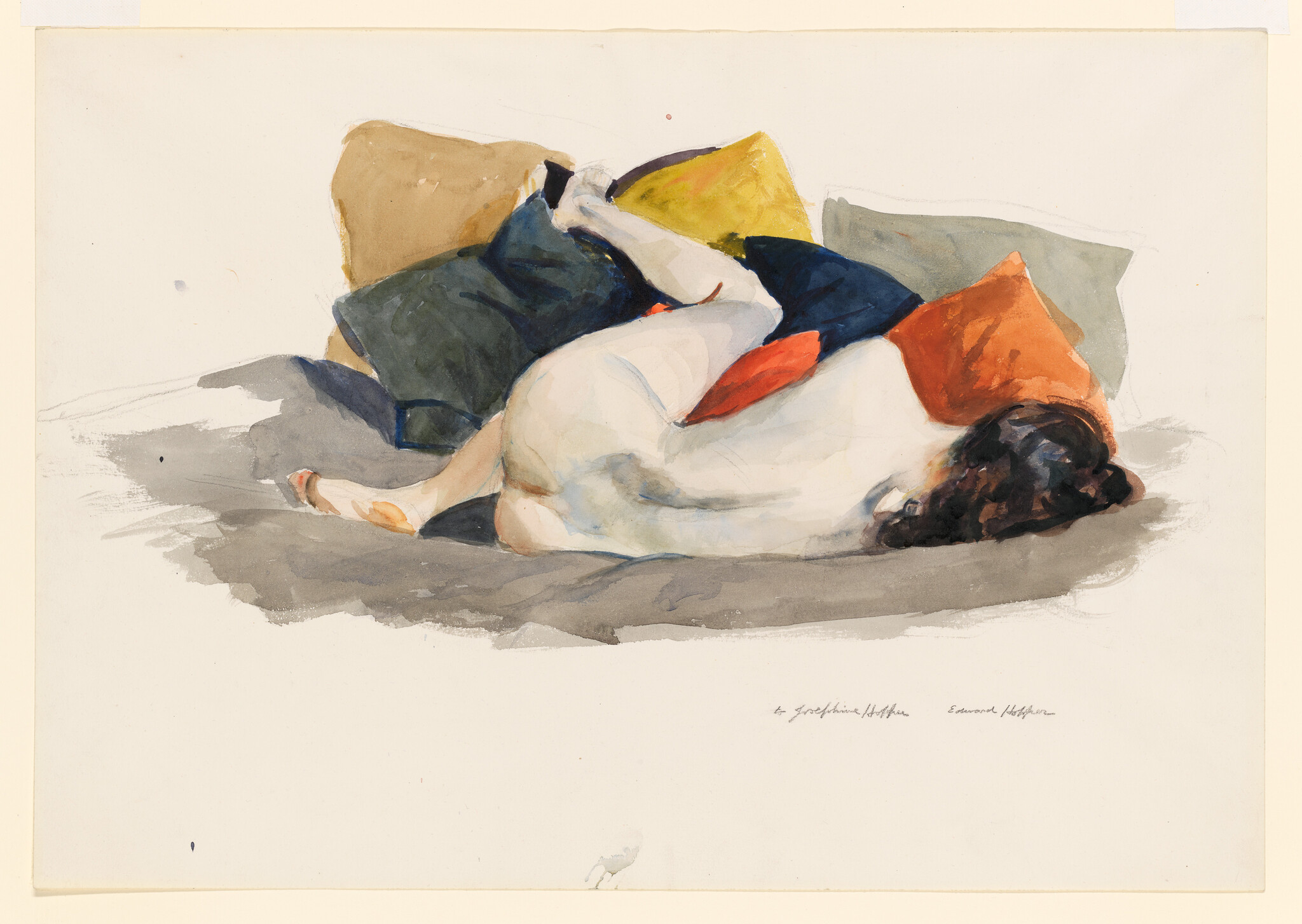 A white and brown dog curled up on colorful pillows and a gray blanket.