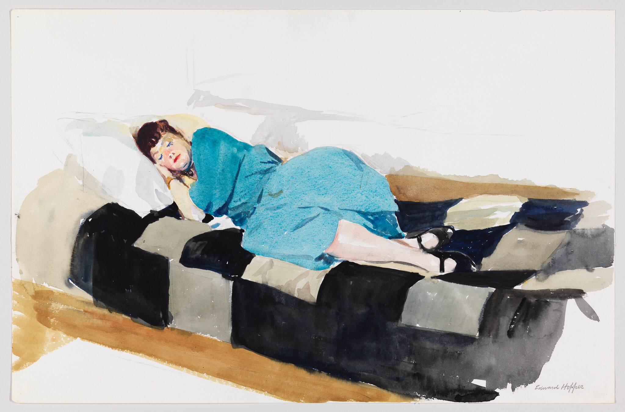 A woman in a blue dress lies curled up on a black and gray patchwork couch.