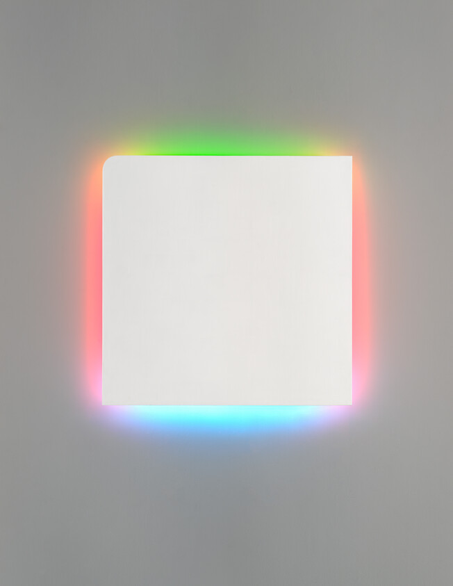 White square wall panel with soft rainbow-colored light glowing around its edges.