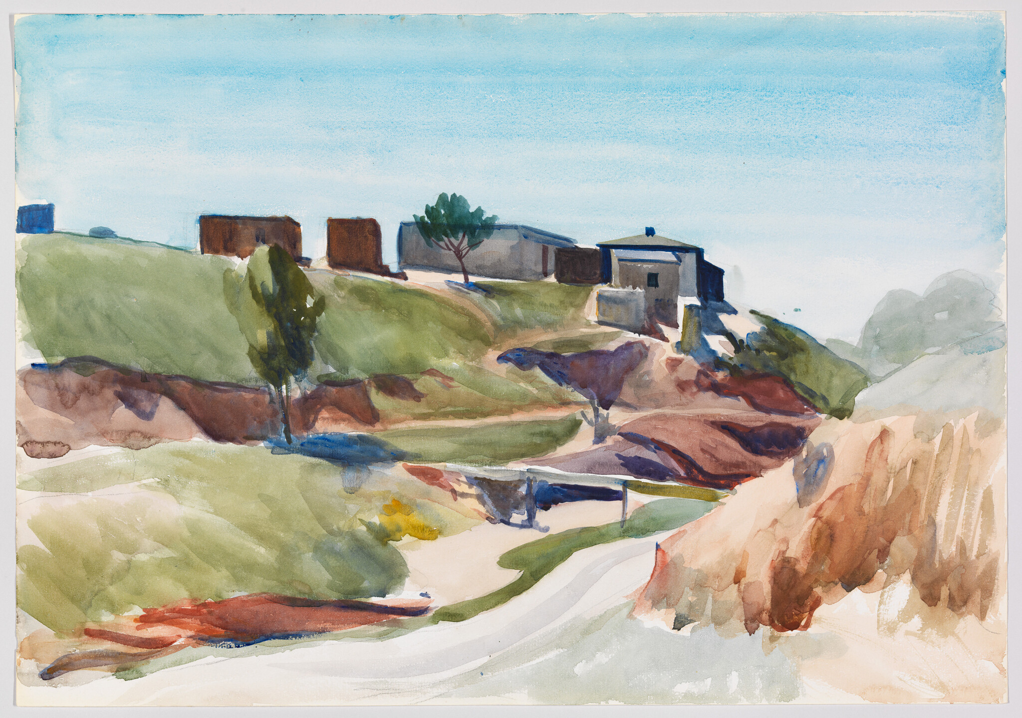 Houses sit atop a grassy hill overlooking a winding dirt path and colorful eroded slopes.
