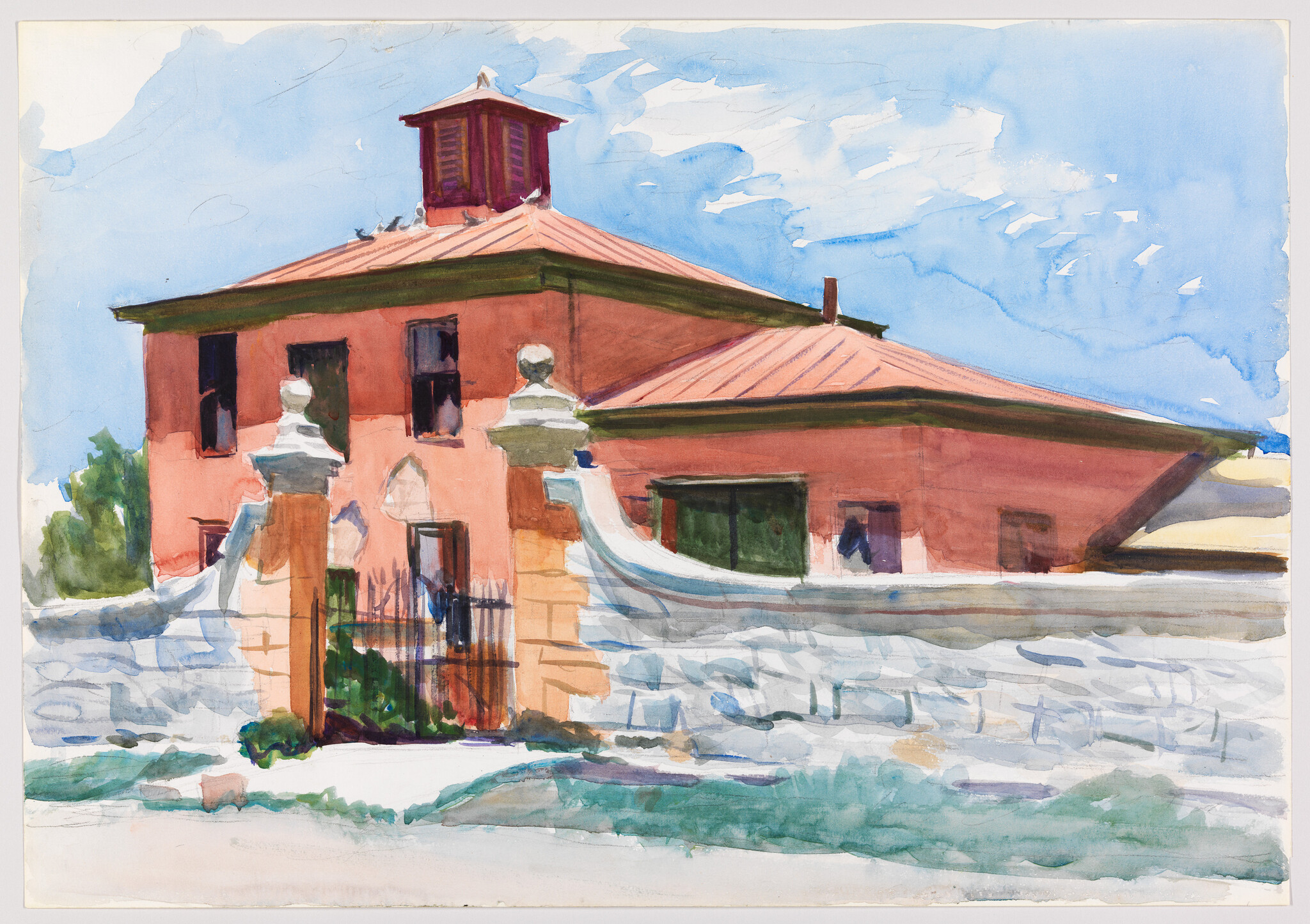A two-story red house with a tiled roof behind a white stone wall and gated entrance.
