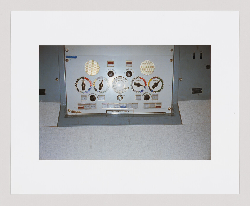 Control panel with multiple circular dials, colored indicator rings, switches, and speaker grilles.