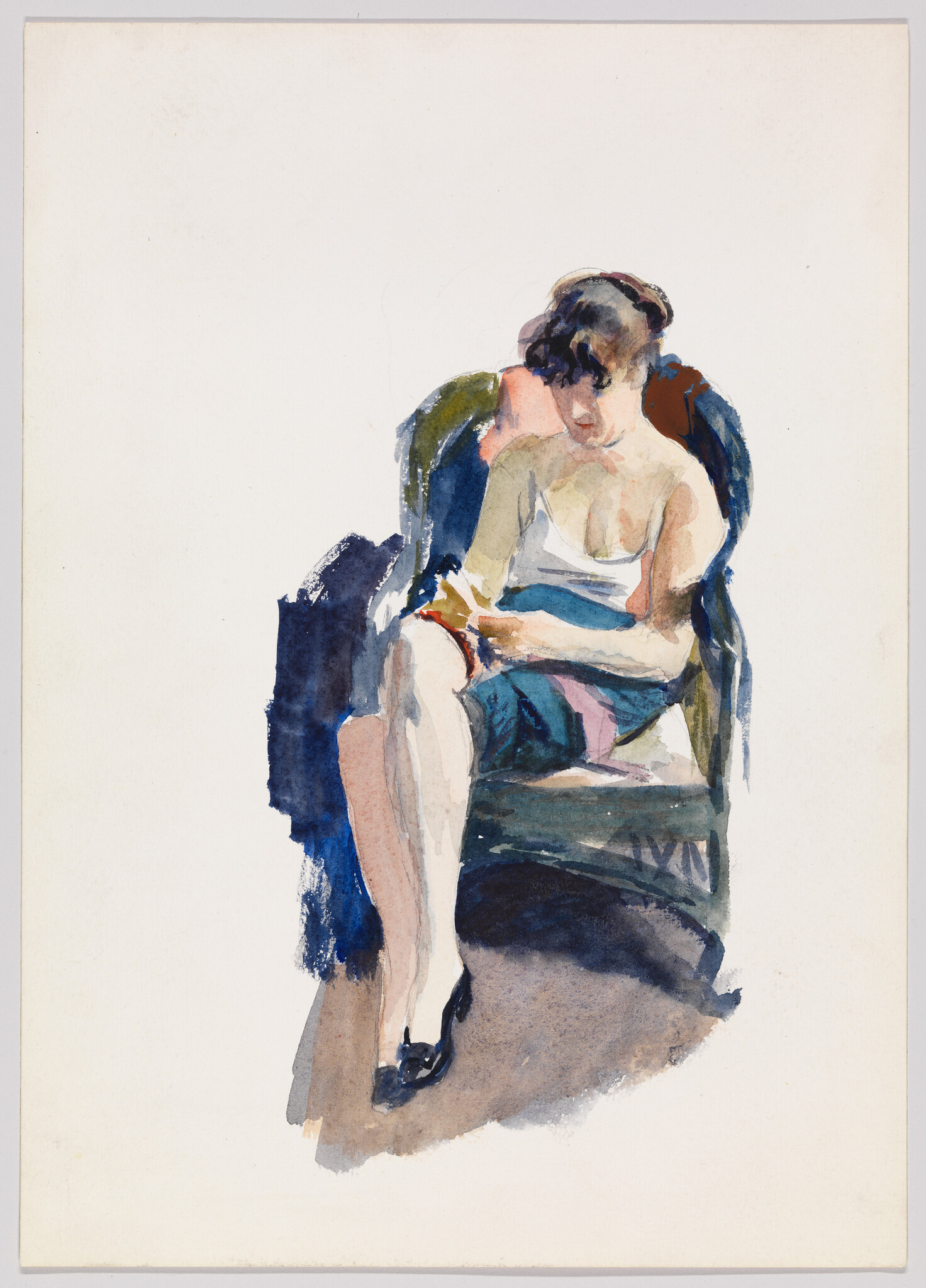 Young woman in a slip sits in a chair reading a small book.