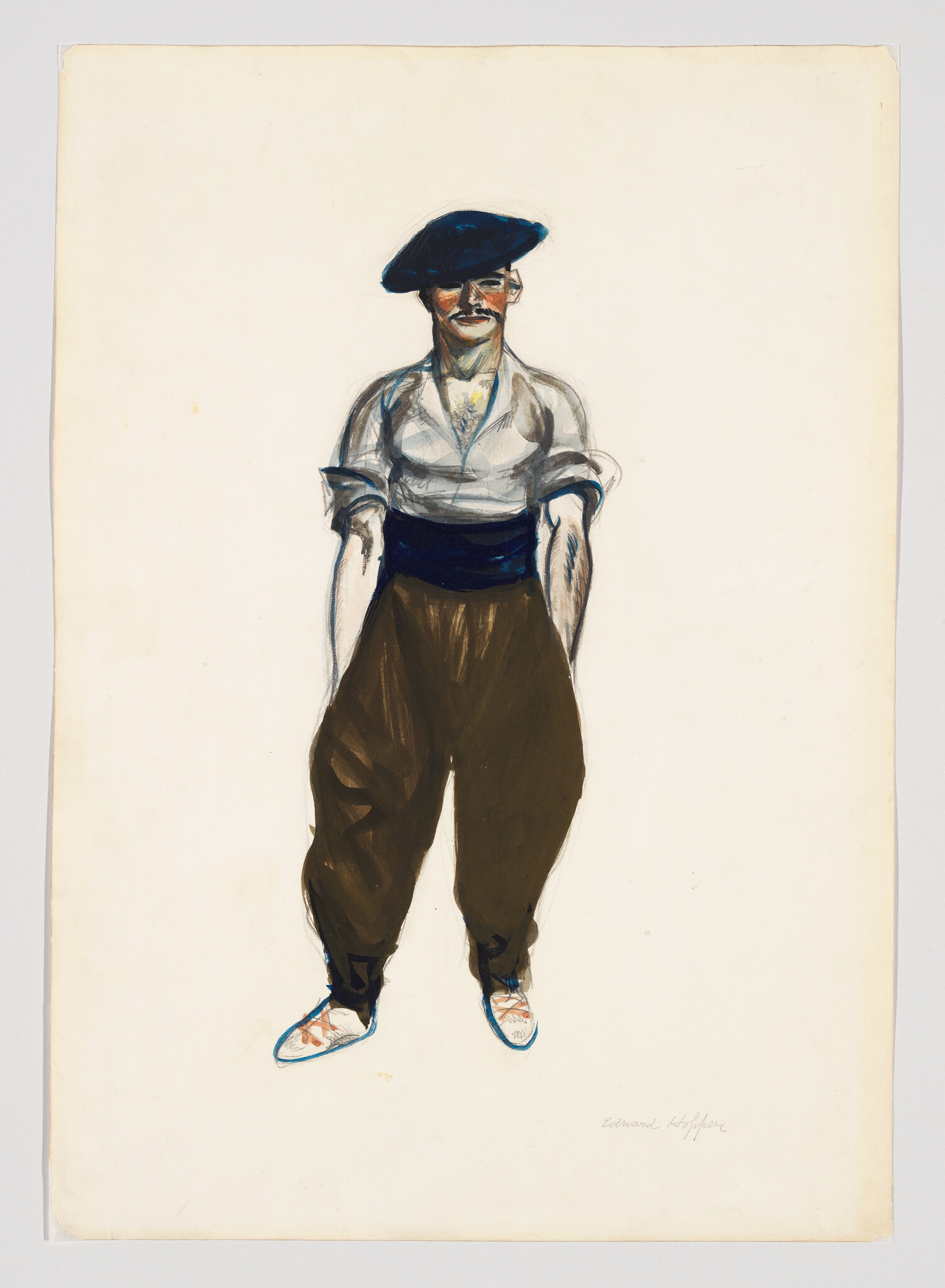 A man in a beret and loose trousers stands with his hands in his pockets.