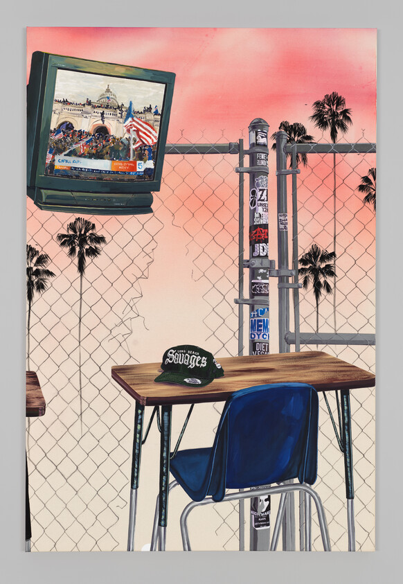 A school desk and blue chair sit outdoors by a chain-link fence with a "Savages" hat on the desk.