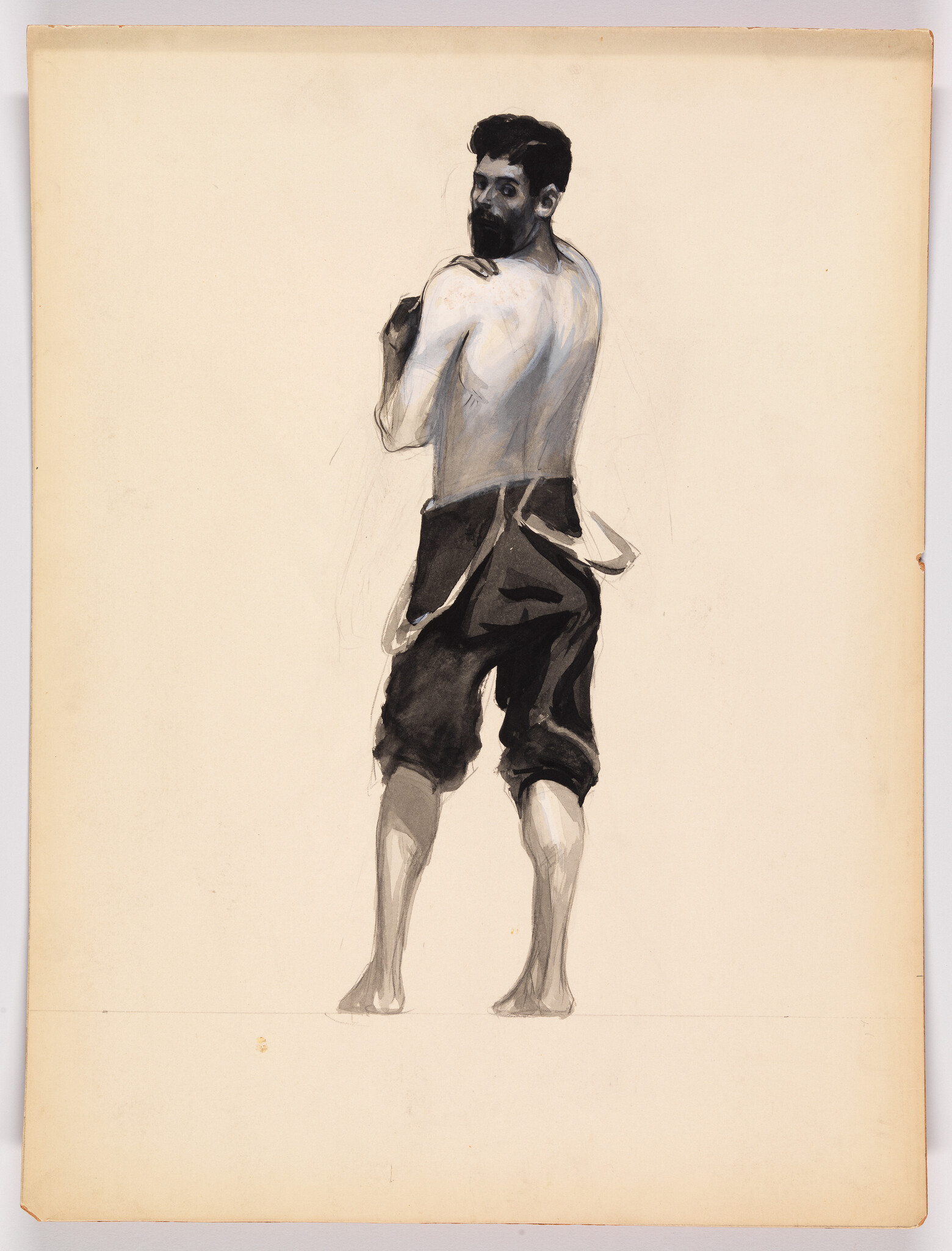 A barefoot bearded man stands turned away, looking over his shoulder with hands raised.