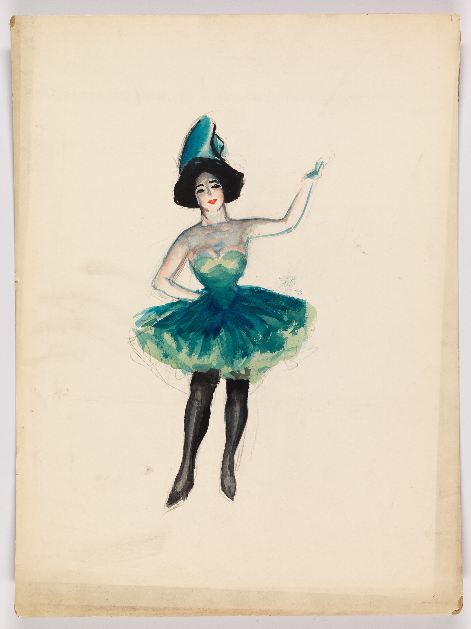 A dancer in a teal tutu and black stockings raises one arm while smiling.