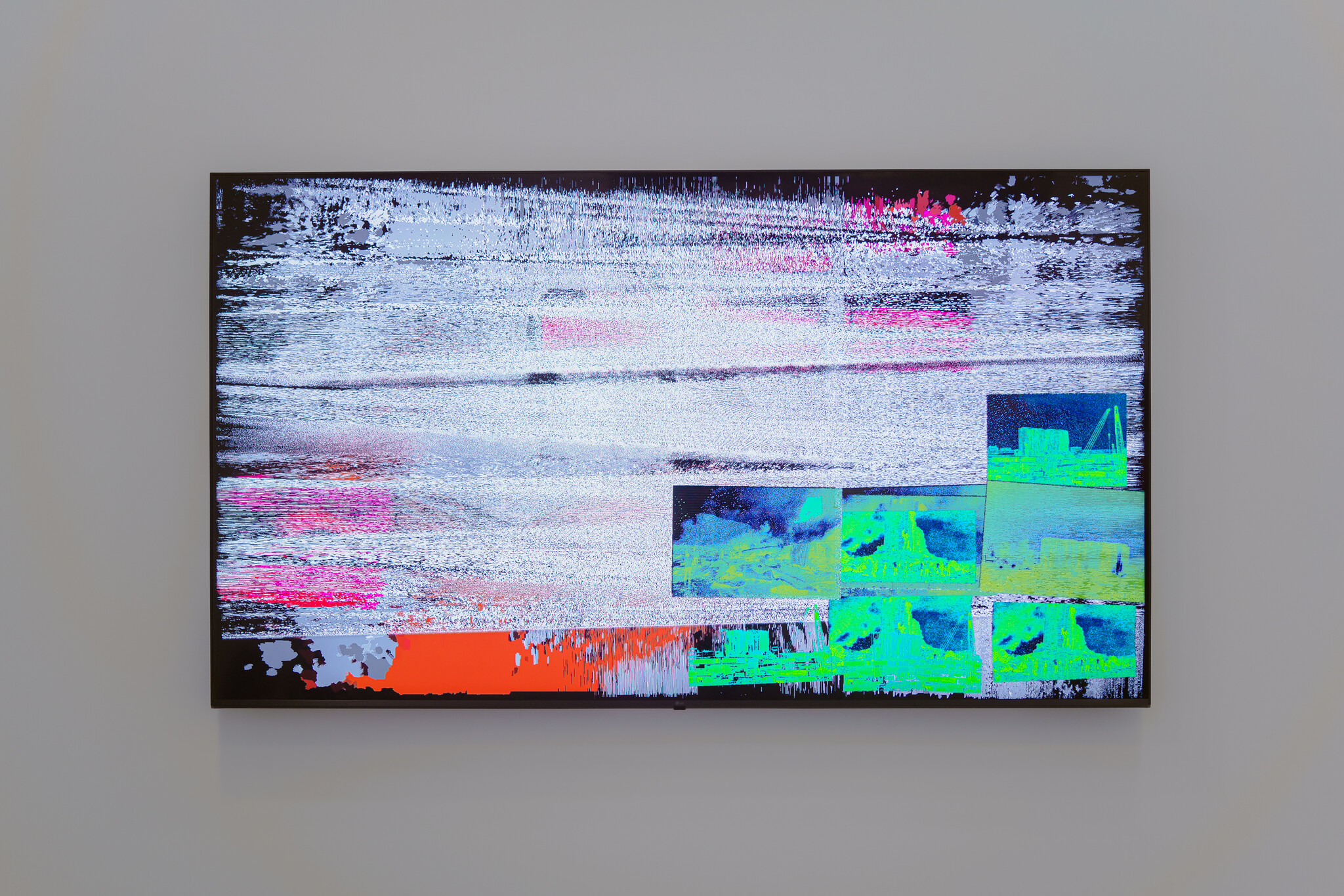 A wall-mounted flat-screen TV displays heavy digital static and colorful glitch blocks across the screen.