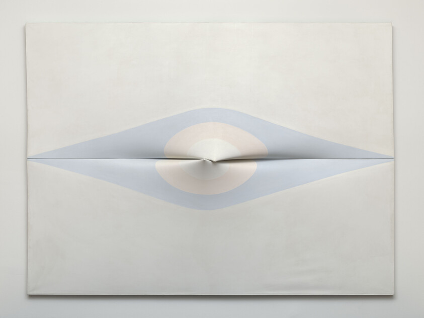 A pale canvas with a horizontal folded slit forming an eye-like blue and pink concentric shape.