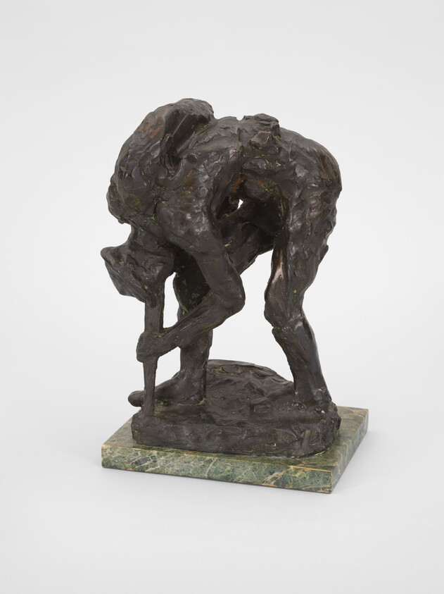 Bronze sculpture of a person bending forward, leaning on a stick, mounted on a green marble base.