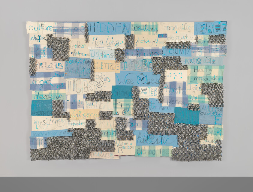 A patchwork textile with blue and cream squares, handwritten words like “TIGERS,” “WATER,” and “resilience” visible.