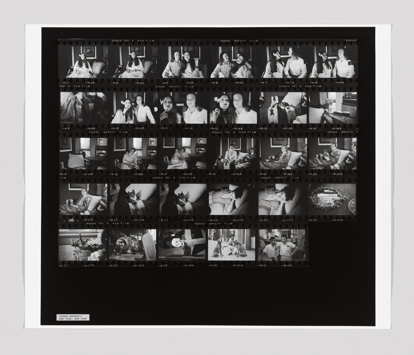 A black and white contact sheet shows two people posing, sitting, and interacting with a cat in a living room.