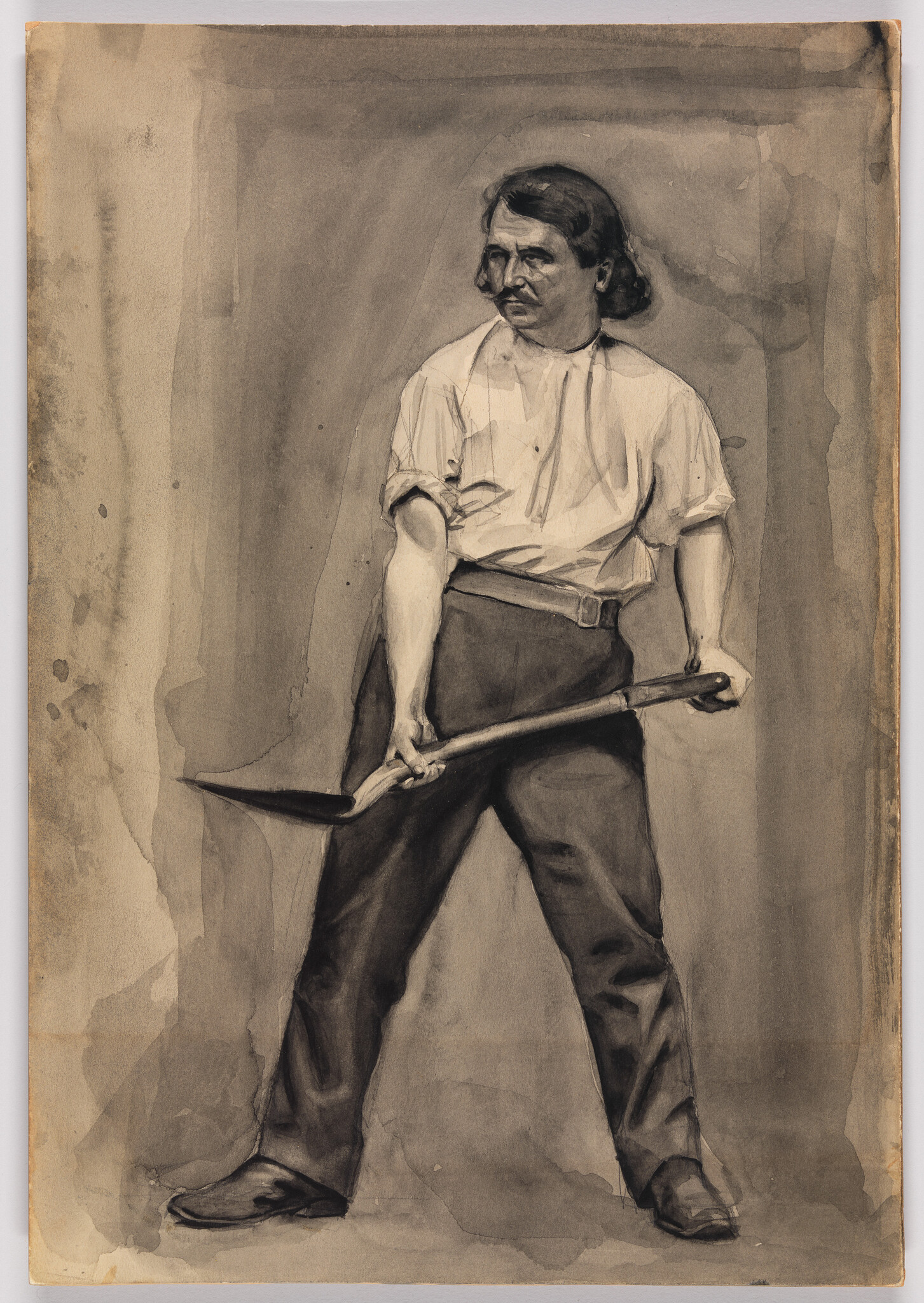 A man stands holding a shovel across his body with a firm, determined stance.