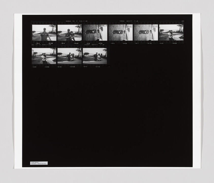 A contact sheet with small black-and-white photos of people outdoors and a cat lying on a stone wall.