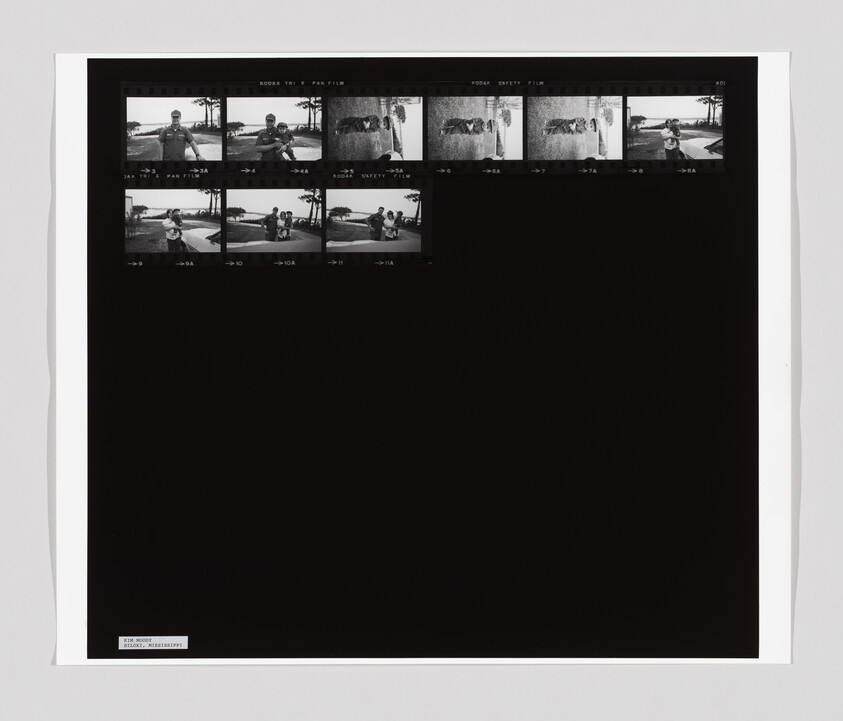 Black contact sheet with small black-and-white negatives showing people outdoors and a dog.