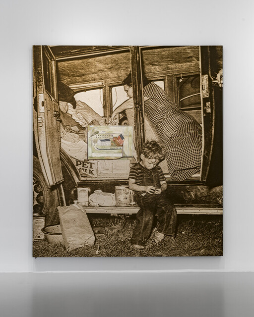 Young boy sits on a car running board fiddling with an object while adults pack the vehicle.