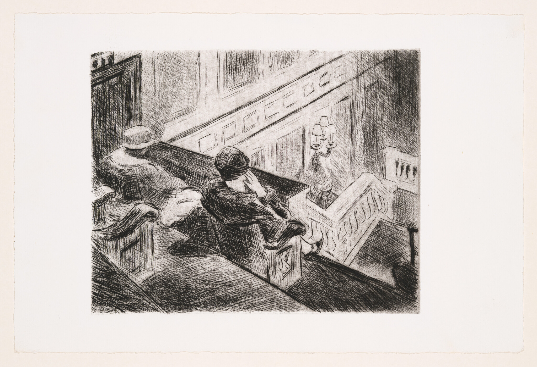 Two people sit on an upper balcony looking down a staircase in a quiet interior.