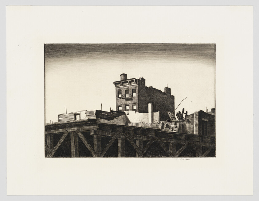 A rooftop scene with a brick building and water tower above wooden support beams.