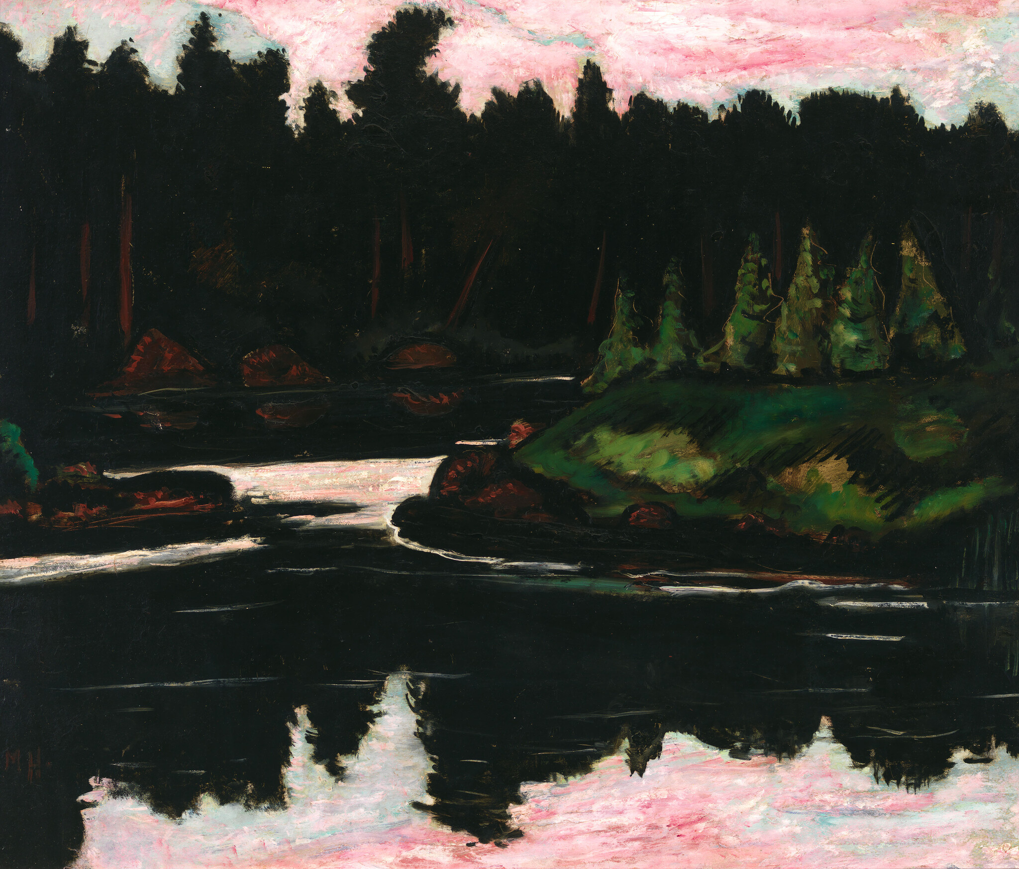 A dark forested shoreline with a river reflecting a pink dusk sky.