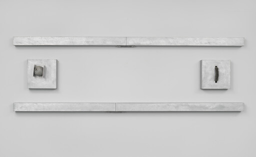 Two long horizontal metal bars with two small square metal boxes between them on a wall.