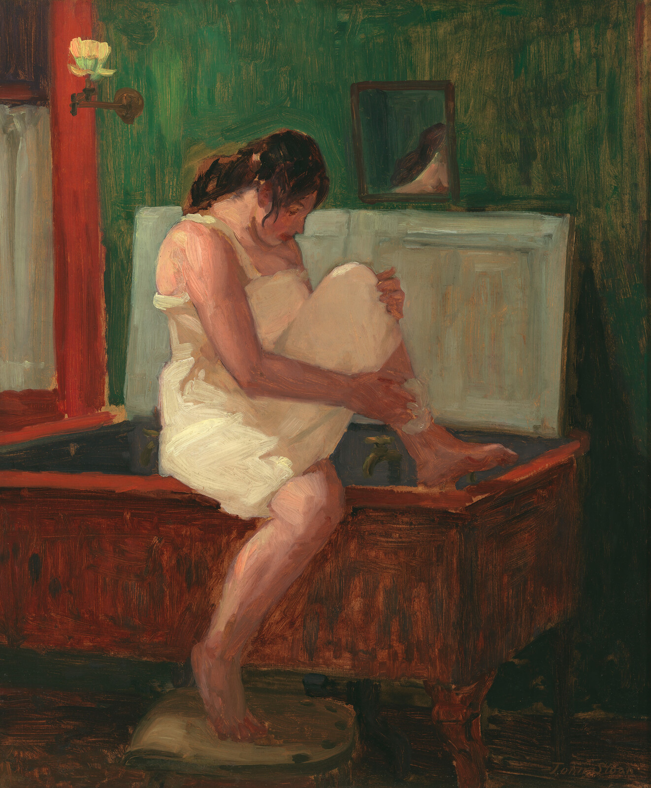 Young woman in a slip sitting on a wooden tub drying her leg.