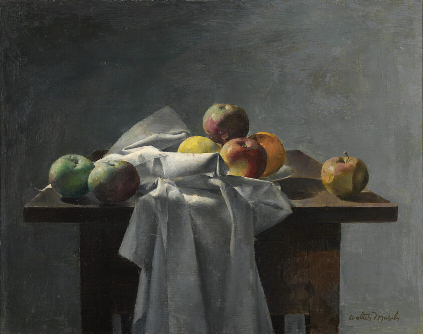 A cluster of apples rests on a wooden table draped with a white cloth.