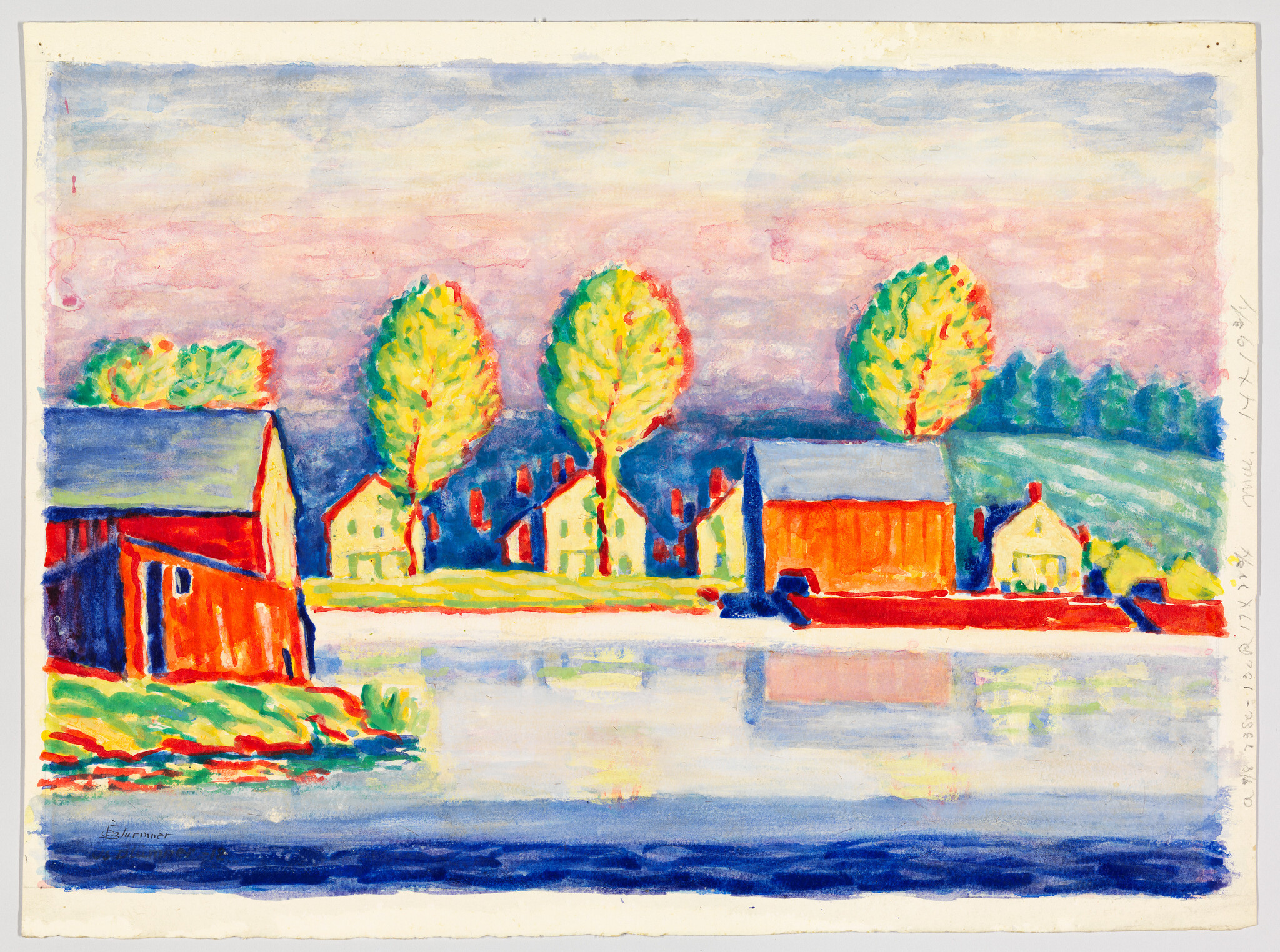 Brightly colored houses and tall trees line a riverbank with their reflections in the water.