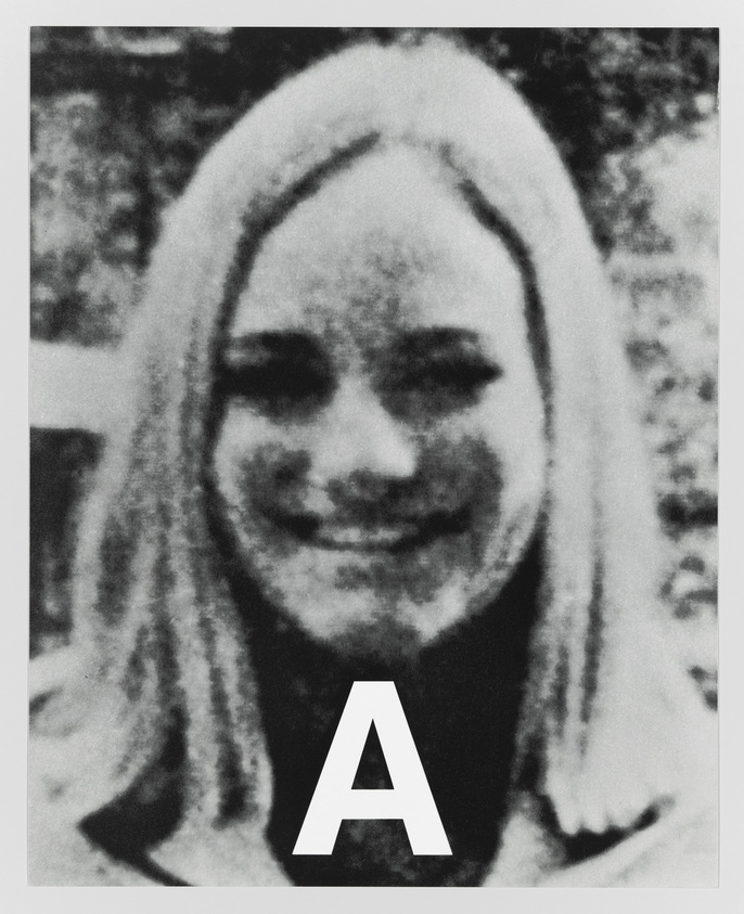 Black and white grainy photo of a smiling woman with long hair, with a large letter "A" superimposed at the bottom center.