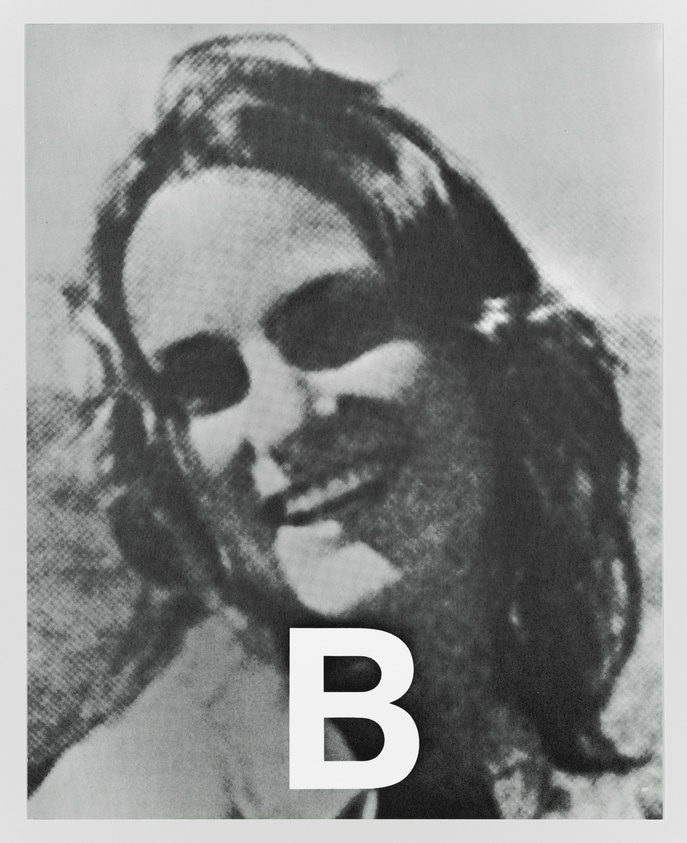 A black and white grainy photo of a smiling woman with her hair pulled back, with a large letter "B" superimposed on the lower part of the image.