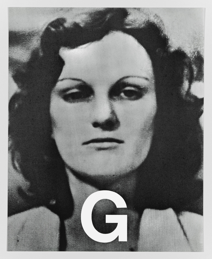 A black and white portrait of a woman with a neutral expression, featuring a large letter "G" superimposed over the lower part of her face and neck.