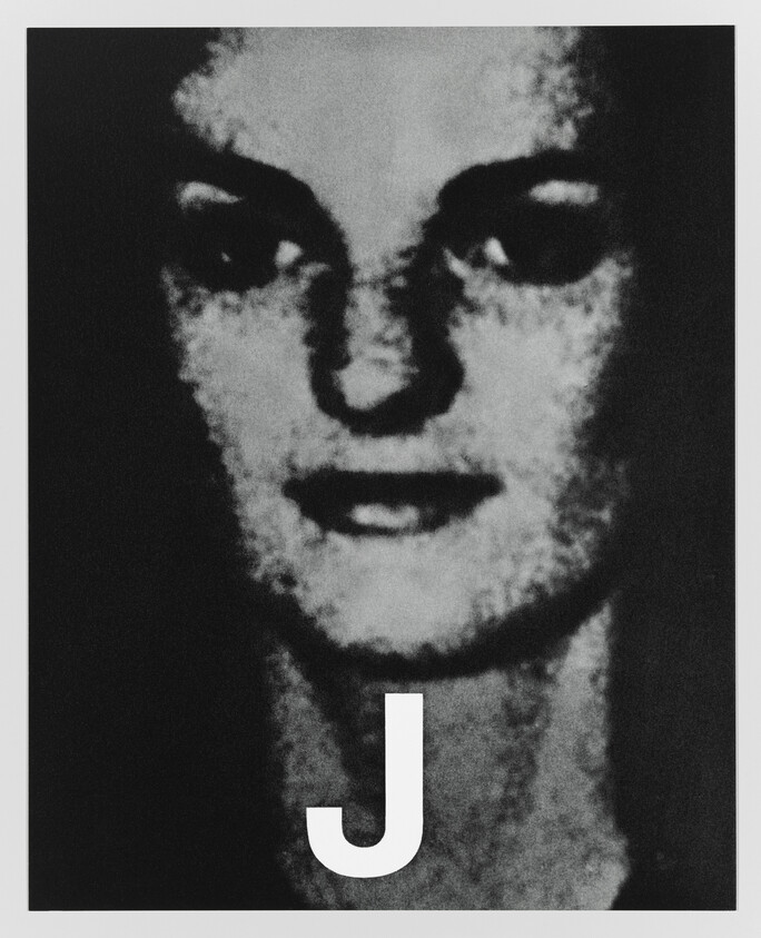 Grainy black and white portrait of a woman's face with a large white letter J at the bottom.