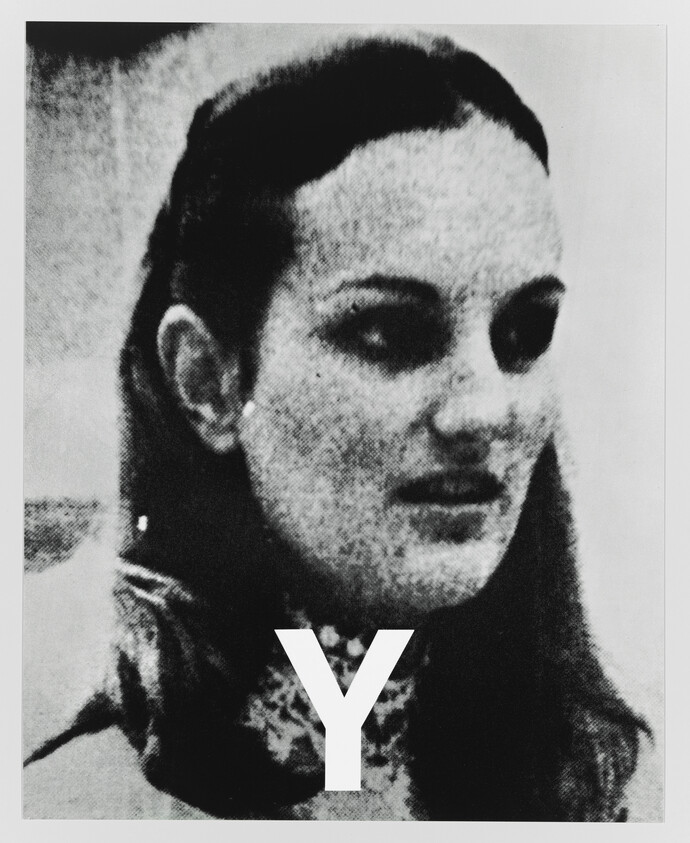 Young woman with long hair and a large letter Y over her chest.