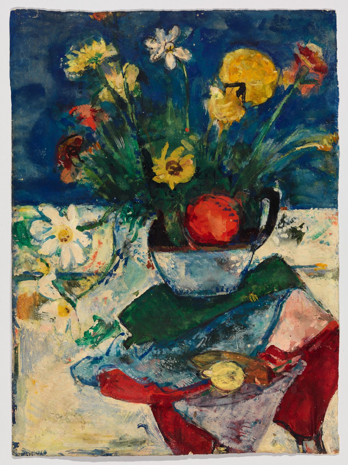 A bright bouquet of mixed flowers and a red apple sit in a blue vase on cloth.