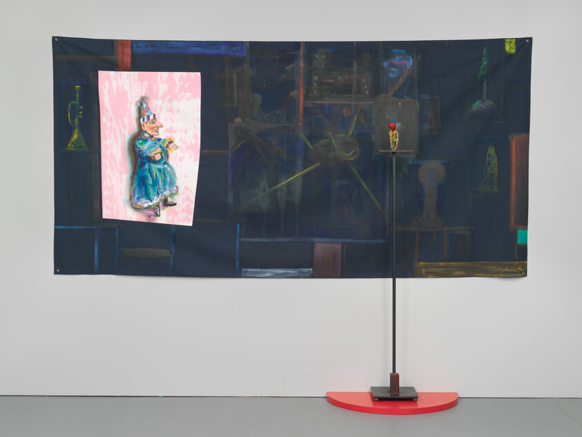 Dark wall hanging with painted pink panel of a woman and small sculpture on tall stand.